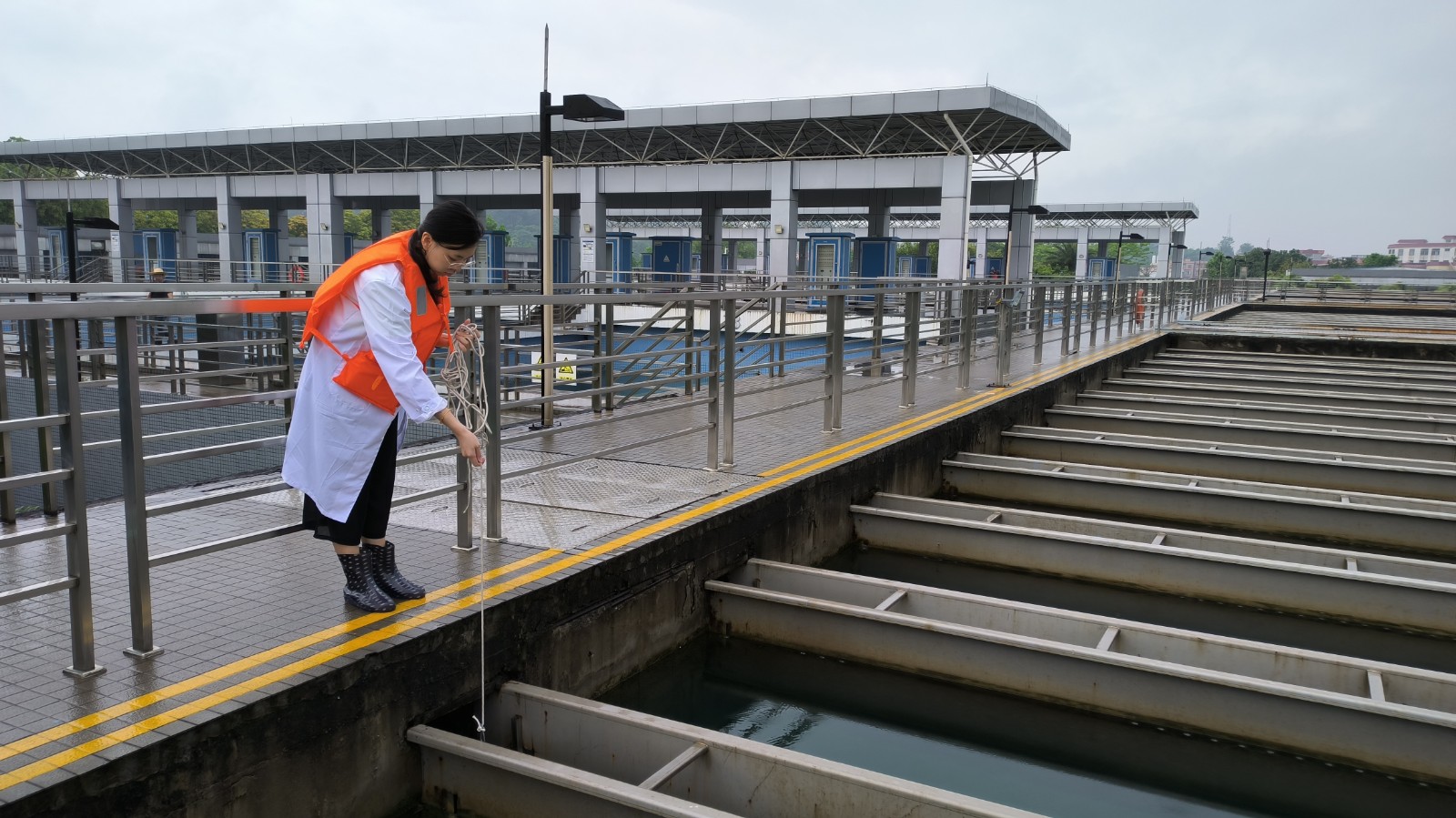 水務(wù)集團(tuán)第六水廠水質(zhì)化驗(yàn)員對平流池水質(zhì)進(jìn)行取樣檢測_副本.jpg